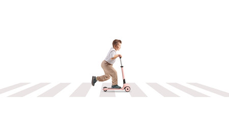 Full length profile shot of a boy on a push scooter at a zebra crossing isolated on white backgroundの写真素材
