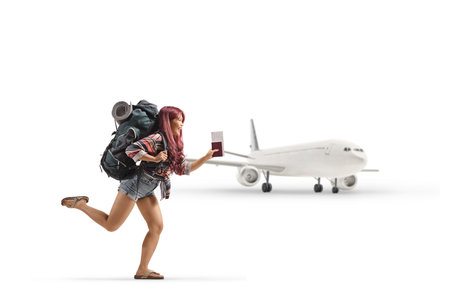 Asian female tourist with a backpack running in front of a plane isolated on white backgroundの写真素材
