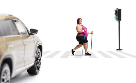 Plus size woman crossing at traffic lights with hiking poles isolated on white backgroundの写真素材
