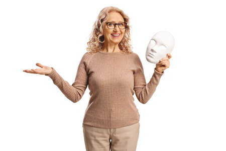 Woman holding a white theater mask and smiling isolated on white backgroundの写真素材