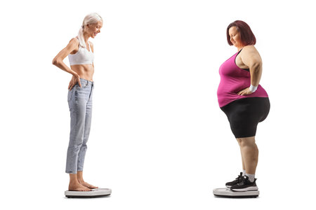 Slim and overweight woman on weight scales isolated on white backgroundの写真素材