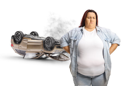 Angry woman with damager car after a car accident isolated on white backgroundの写真素材