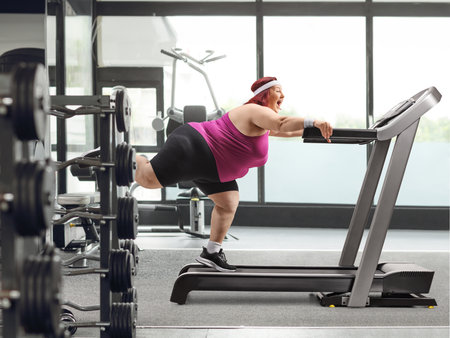 Overweight woman working out on a treadmill at a gymの写真素材