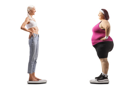 Slim and overweight woman standing on weight scales isolated on white backgroundの写真素材