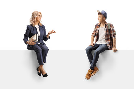 Teacher sitting on a panel and talking to a male student isolated on white backgroundの写真素材