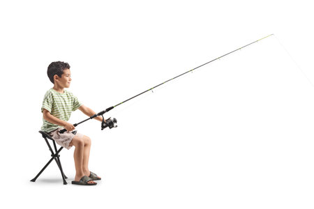 Kid sitting and catching fish with a fishing pole isolated on white backgroundの写真素材