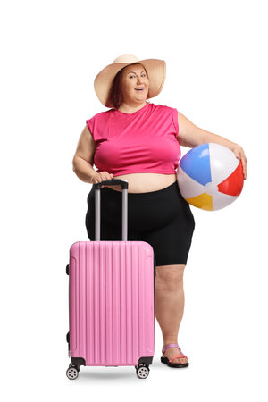 Happy woman with a pink suitcase and beach ball on a summer vacation isolated on white backgroundの写真素材