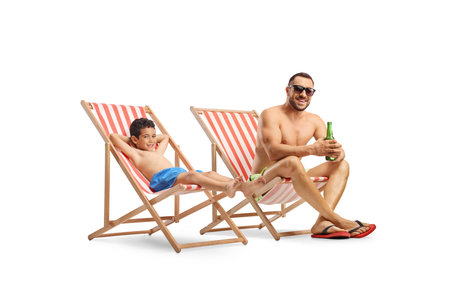 Kid with father on a summer vacation, sunbathing on loungers isolated on white backgroundの写真素材