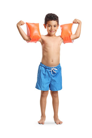 Happy boy in swimming shorts wearing swimming arm bands isolated on white background