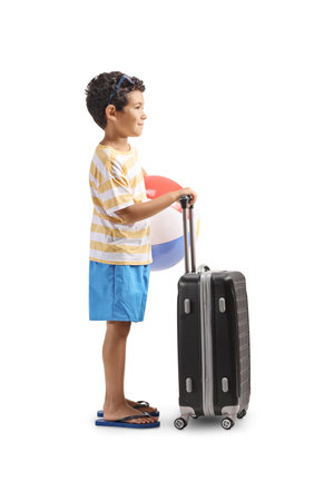 Boy with a beach ball standing with a suitcase isolated on white backgroundの写真素材