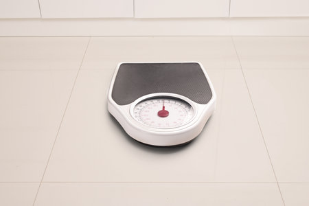Weight scale on a tiled floorの写真素材