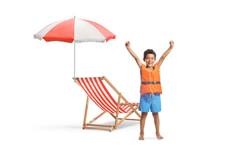 Boy in swimming shorts wearing a life jacket and gesturing happiness on white backgroundの写真素材