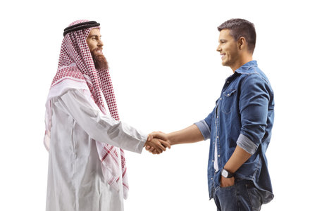 Profile shot of an arab man shaking hand with a casual young man isolated on white backgroundの写真素材