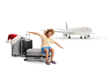 Excited boy traveling with a plane on christmas isolated on white backgroundの写真素材