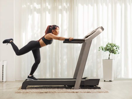 Young woman trying to run fast on a treadmill
