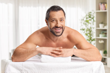 Man laying on a massage bed and smilingの写真素材