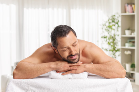 Man relaxing after a back massage in a roomの写真素材