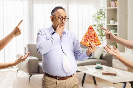 People scolding a mature man with a slice of pizzaの写真素材