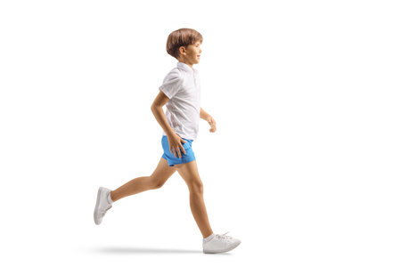 Full length profile shot of boy running isolated on white backgroundの写真素材