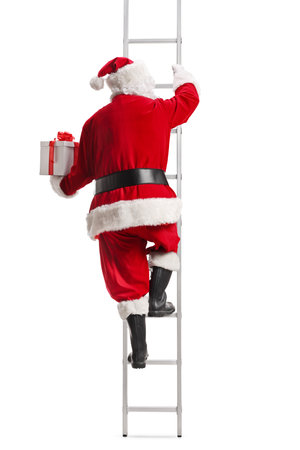Back view of Santa Claus with a present climbing a ladder isolated on white backgroundの写真素材