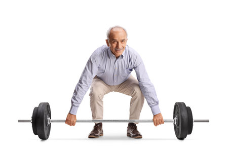 Casual elderly man trying to lift weights isolated on white backgroundの写真素材