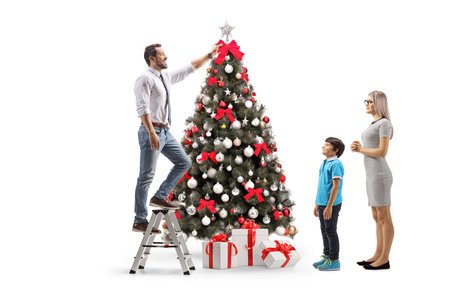 Family decorating a christmas tree isolated on white backgroundの写真素材