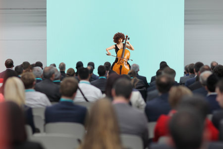 Woman playing a cello in front of audience in a hallの写真素材
