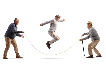 Seniors playing skipping rope isolated on white backgroundの写真素材