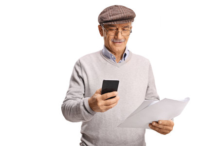 Elderly man holding a paper document and looking at a smartphone isolated on white background
