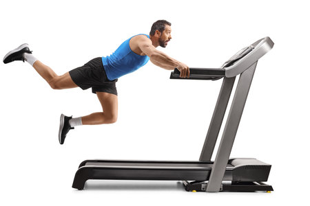 Man falling from a treadmill with legs in the air isolated on white backgroundの写真素材