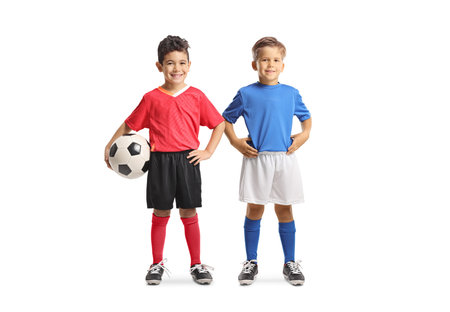 Boys in football jerseys holding a ball and smiling isolated on white backgroundの写真素材