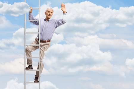 Elderly man standing on a ladder in the sky and waving at cameraの写真素材