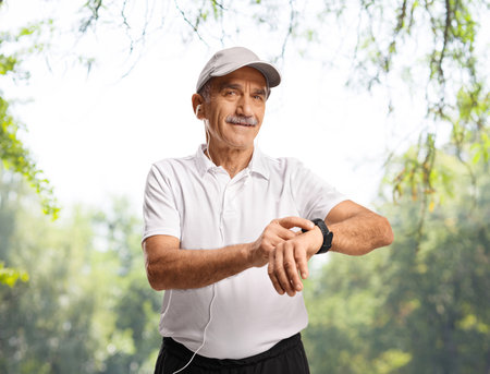 Mature man in sportswear with a smart watch in a parkの写真素材