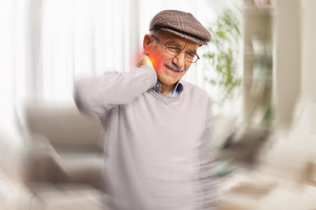 Elderly man feeling dizzy at homeの写真素材