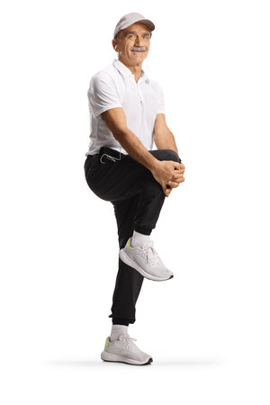 Fit mature man in sportswear stretching knee isolated on white backgroundの写真素材