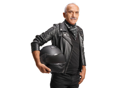 Mature man in a leather jacket holding a black motorbike helmet isolated on white background