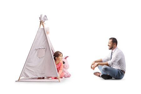 Father and daughter playing with a teepee tent isolated on white background