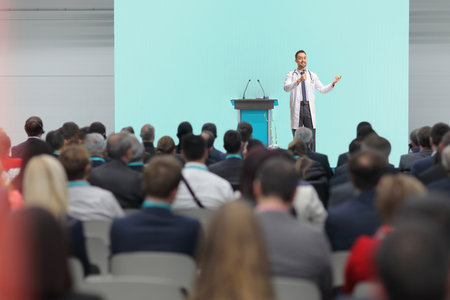 Doctor giving a speech on stage at a medical conference in front of audienceの写真素材