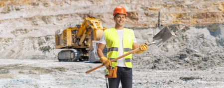Construction worker holding a shovel on a mining pit