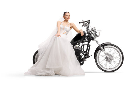 Bride in a white wedding dress sitting on a black chopper motorcycle isolated on white backgroundの写真素材