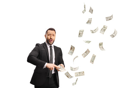 Businessman in a black suit throwing money isolated on a white background