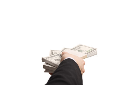 Hand of a person in a suit holding stacks of dollar bills isolated on white background