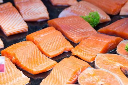 Raw salmon steaks and fillets on the ice.