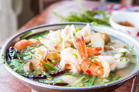 Tom Yum Goong, spicy soup with shrimp and seafood in a hot pot, thai cuisine.の写真素材