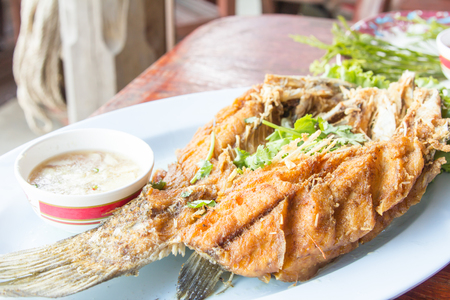 Fried snapper with chili sauce on the plate.の写真素材