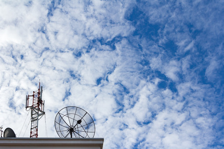 Satellite dish and Antenna with cloudy blue sky background.の写真素材