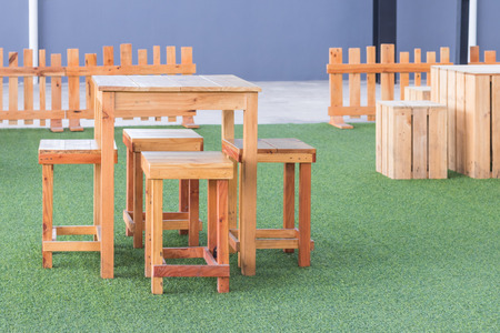 The wooden table and chair on green grass.