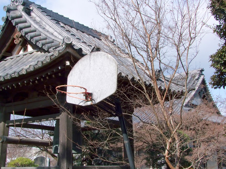 Merging modern and ancient, a basketball hoop in front of a Japanese shrine.の写真素材