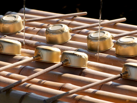 Golden, wooden, cleansing cups at a Japanese shrine/temple.の写真素材