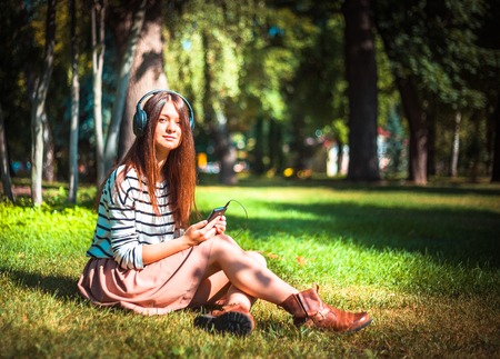 Student girl outside listening to music on headphonesの写真素材
